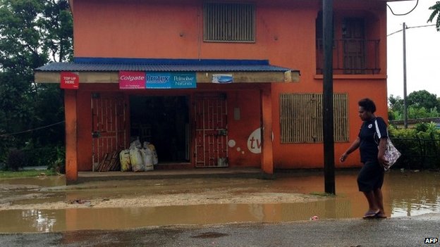 A resident walking past localized flooding caused by rains brought by Tropical Cyclone Pam, near the Vanuatu capital of Port Vila