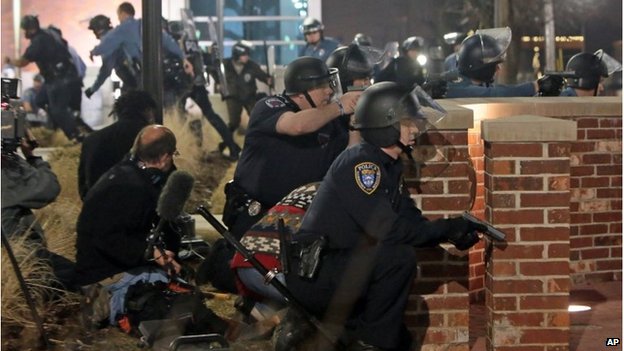 Police take cover after two officers were shot in Ferguson, Missouri, 12 March 2016